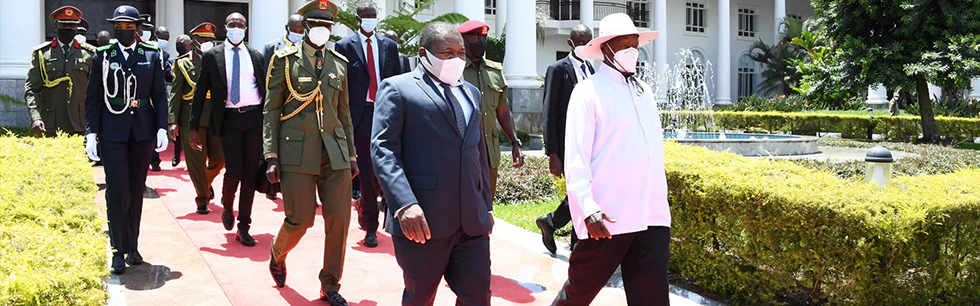 Presidentes Filipe Nyusi e Yoweri Museveni caminham no palácio presidencial em Uganda