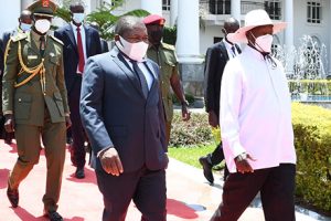 Presidentes Filipe Nyusi e Yoweri Museveni caminham no palácio presidencial em Uganda
