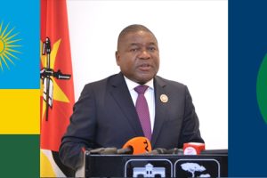 No centro, o Presidente Filipe Nyusi, à esquerda a bandeira do Ruanda e à direita a bandeira da SADC